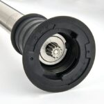 תקריב של חפץ מתכתי גלילי עם רכיב "LOCK" שחור ומרכז דמוי גלגל שיניים, כפי שנמצא במכשיר בלנדר מוט בלנדר ידני 40 ס"מ (רמבו).