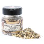 צנצנת של תערובת תבלינים עם תווית בעברית, ולידה ערימה של התבלינים המעורבבים על רקע לבן.