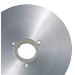 תקריב של להב מסור מתכתי עגול עם חור במרכזו ושלושה ברגים קטנים מסביבו.